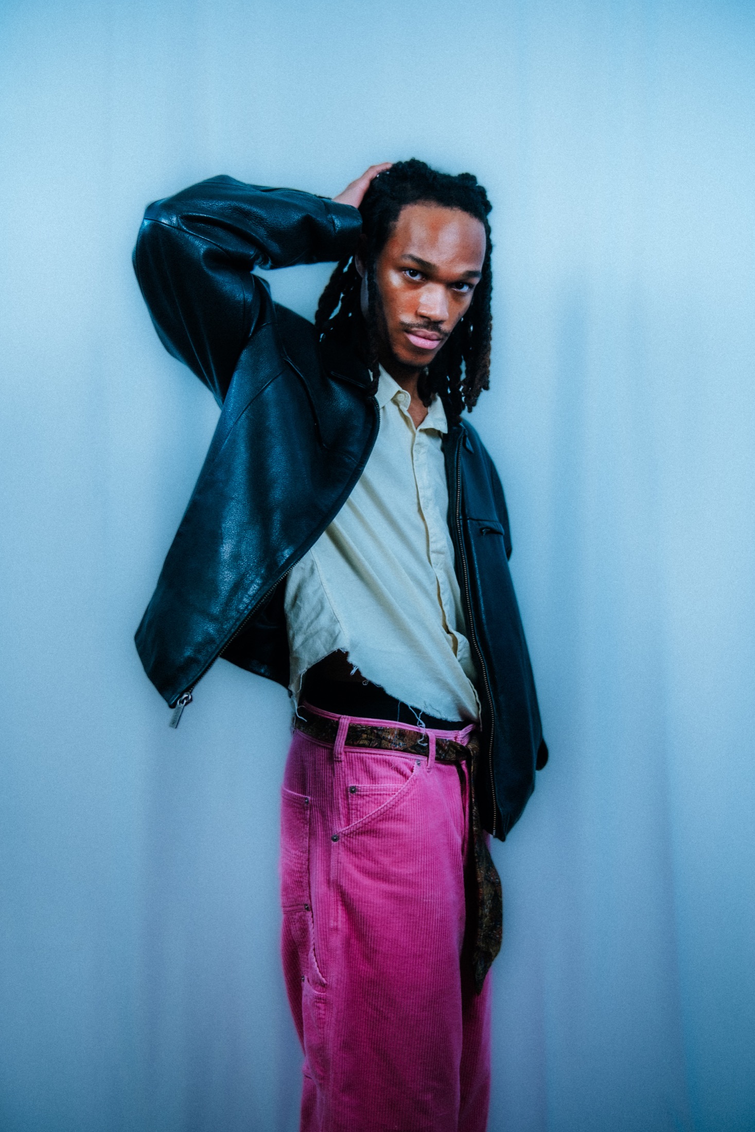 Kamari in a black leather jacket and pink pants