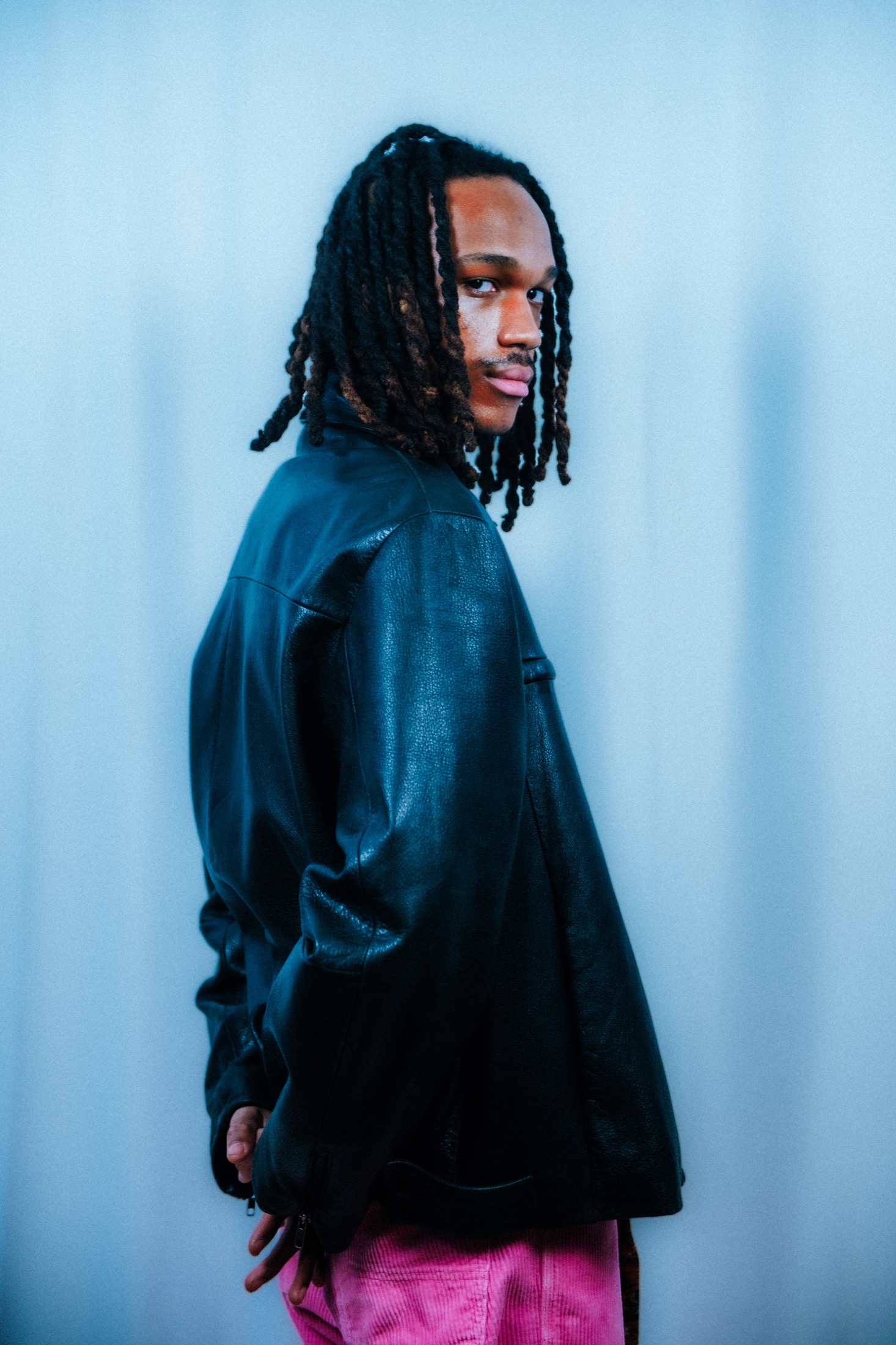 Kamari in profile wearing a black leather jacket