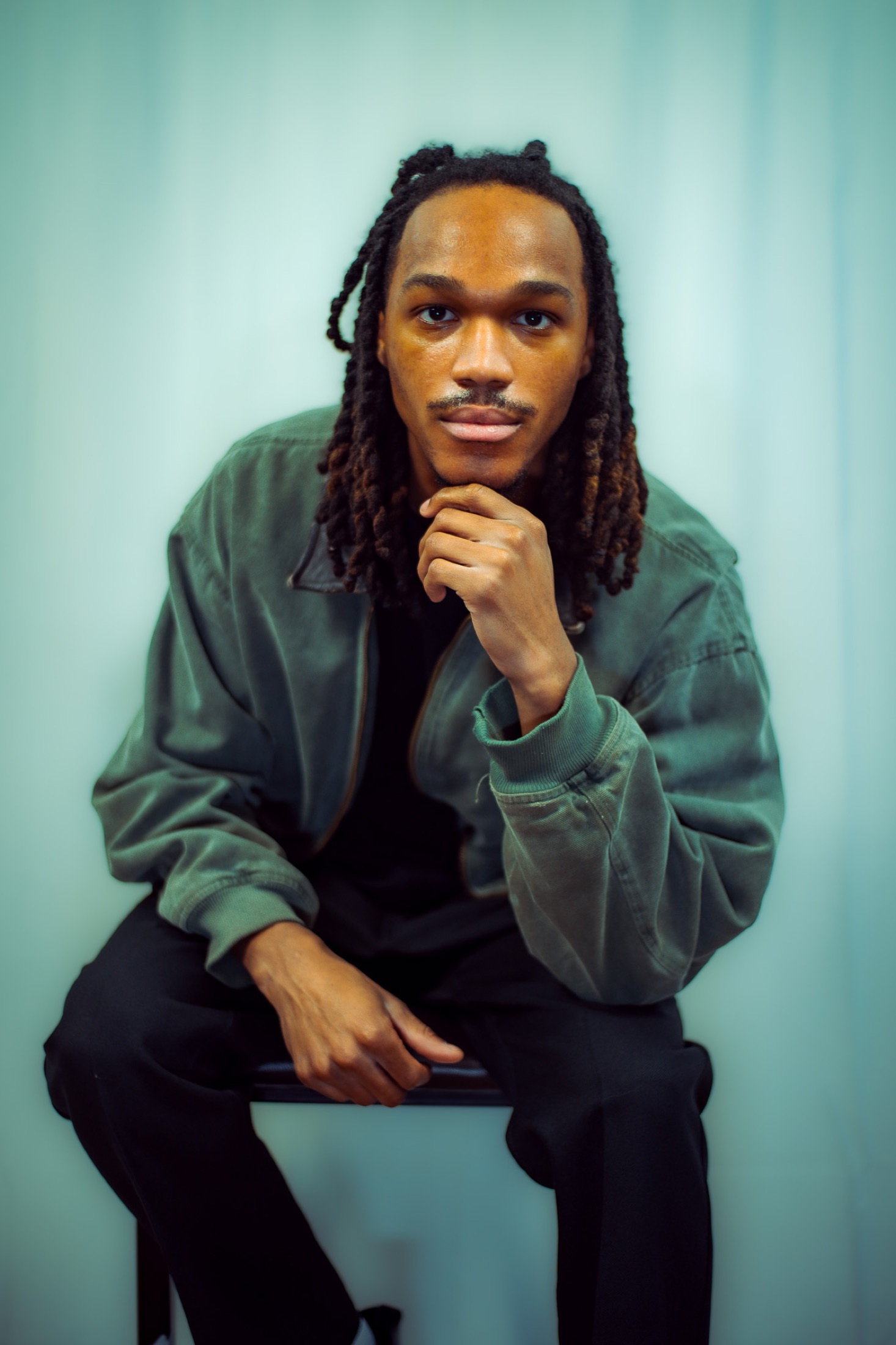 Kamari seated in a green jacket